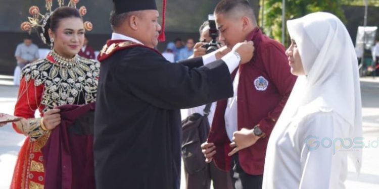 Rektor UNG Eduart Wolok saat menyematkan almamater kepada mahasiswa baru`