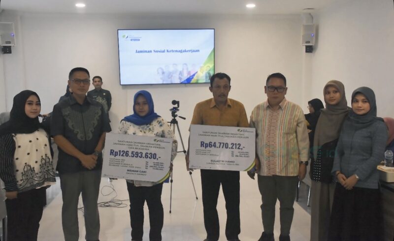 Kepala BPJS Ketenagakerjaan Cabang Gorontalo, Sanco Simanulang didampingi Kepala Dinas Tenaga Kerja ESDM dan Transmigrasi Provinsi Gorontalo, Wardoyo M. Pongoliu saat menyerahkan santunan jaminan kematian, jaminan hari tua, jaminan pensiun, serta beasiswa kepada dua ahli waris keluarga disela kegiatan sosialisasi program BPJS Ketenagakerjaan yang dilaksanakan di Aula Kantor BPJS Ketenagakerjaan Gorontalo, Kamis (18/9/2025). (Foto Indra/Gopos)