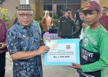 Bupati Gorontalo, Sofyan Puhi, menyerahkan bantuan untuk korban puting beliung
