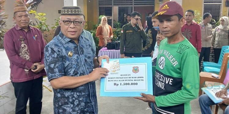 Bupati Gorontalo, Sofyan Puhi, menyerahkan bantuan untuk korban puting beliung