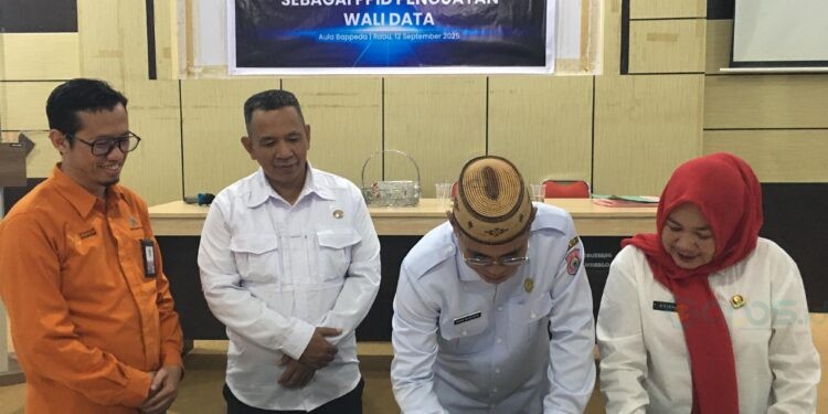 Sekda Bone Bolango, Iwan Mustapa saat menandatangani komitmen bersama pelaksanaan penguatan Wali Data bersama para Sekretaris OPD di Pemerintah Kabupaten Bone Bolango. (Foto Indra/Gopos)