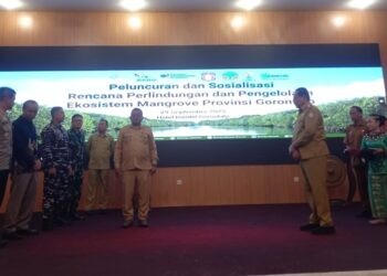 Asisten bidang Administrasi Umum Setda Gorut saat menerima Dokumen Rencana Perlindungan dan Pengelolaan Ekosistem Mangrove yang diserahkan langsung oleh Gubernur Gorontalo, Gusnar Ismail bertempat di Ballroom Hotel Damhil. (Gusti/Gopos)