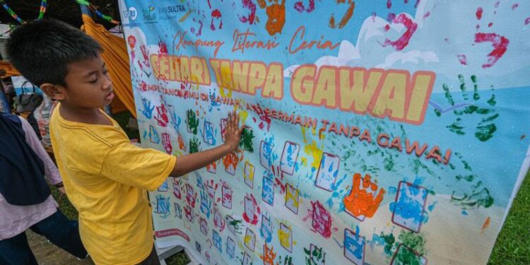 Seorang anak menempelkan tangannya pada papan penanda kegiatan sehari tanpa gawai di Kendari, Sulawesi Tenggara, Sabtu (5/7/2025). Praktik sehari tanpa gawai yang diinisiasi oleh Forum Taman Baca Masyarakat (FTBM) Sulawesi Tenggara tersebut diikuti 147 peserta terdiri dari anak, orang tua, siswa dan mahasiswa bertujuan memaksimalkan kinerja otak dengan menghindari penggunaan gawai sekaligus meningkatkan kualitas pengasuhan dalam keluarga. ANTARA FOTO/Andry Denisah/nz