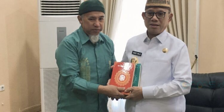 Bupati Ismet Mile menerima secara simbolis 7 ribu wakaf Al-quran dari Chief of Networking Badan Wakaf Al-Qur’an, Hazairin Hasan di Ruang Kerja Bupati, Selasa (14/10/2025). (Foto Indra/Gopos)