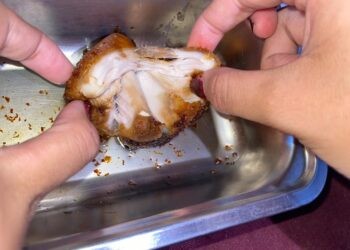 Salah seorang siswa SMA Negeri 1 Telaga memperlihatkan menu MBG berupa potongan daging ayam yang tak layak konsumsi.(Istimewa)