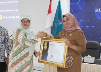 Sekretaris Utama BKN, Imas Sukmariah saat menyerahkan Penghargaan Terbaik I atas Pencapaian Progres Nilai Kualitas Data ASN kepada Kepala BKPSDM Bone Bolango, Friske Aryanti Usman, Senin (20/10/2025). (F.Istimewa)