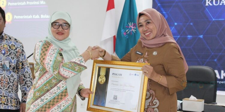 Sekretaris Utama BKN, Imas Sukmariah saat menyerahkan Penghargaan Terbaik I atas Pencapaian Progres Nilai Kualitas Data ASN kepada Kepala BKPSDM Bone Bolango, Friske Aryanti Usman, Senin (20/10/2025). (F.Istimewa)
