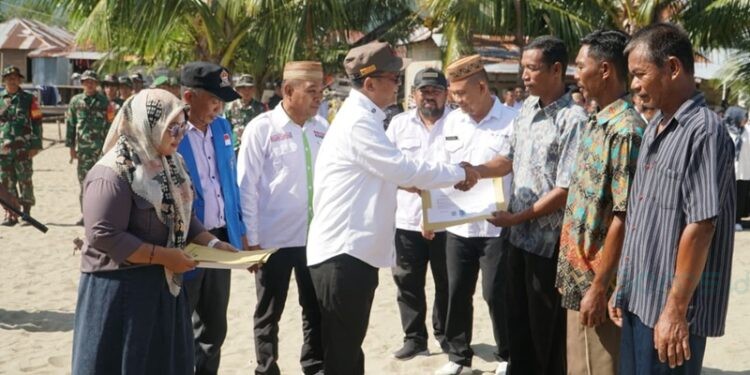 Bupati Gorontalo Utara, Thariq Modanggu saat mengukuhkan Relawan Gerakan Masyarakat Cinta Laut di Pantai Bulontio Barat, Rabu (15/10/2025).(Larso/Humas)