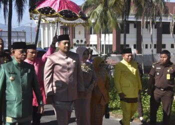 Kepala Kejaksaan Negeri (Kejari) Bone Bolango yang baru, Feddy Hantyo Nugroho, bersama Ketua Ikatan Adhyaksa Dharmakarini (IAD), Dina Feddy Hantyo disambut dengan adat mopotilolo di Kabupaten Bone Bolango, Senin (3/11/2025). (Foto Indra/Gopos)
