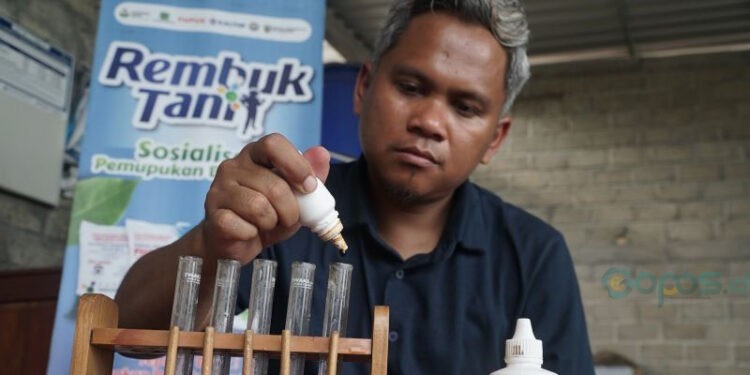 Petugas agronomis mobil uji tanah Pupuk Indonesia memasukkan reagen ke dalam pipet berisi sampel tanah pertanian untuk dianalisis di Desa Suwaloh, Tulungagung, Jawa Timur, Selasa (25/11/2025). Pemeriksaan sampel tanah gratis oleh Pupuk Indonesia yang mengukur tingkat kesuburan dan PH tanah itu dilakukan untuk memberikan rekomendasi pemupukan yang tepat sehingga produktivitas dan hasil panen petani dapat meningkat. ANTARA FOTO/Destyan Sujarwoko (ANTARA FOTO/Destyan Sujarwoko)