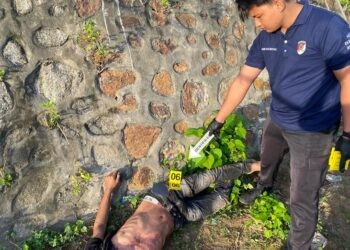 Petugas kepolisian sedang melakukan olah TKP di lokasi penemuan jasad pria di Bone Bolango. (F. Istimewa)