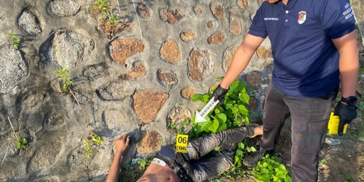 Petugas kepolisian sedang melakukan olah TKP di lokasi penemuan jasad pria di Bone Bolango. (F. Istimewa)