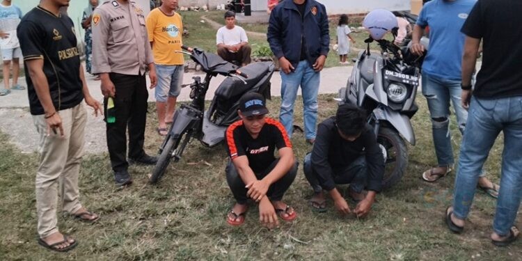 Dua terduga pelaku penikaman (jongkok) saat diamankan aparat kepolisian, Kamis (1/1/2026).(F. Istimewa)