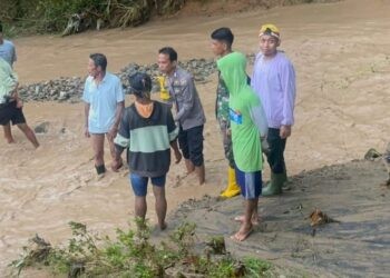 Aparat kepolisian dibantu warga sekitar saat mencari keberadaan korban yang hanyut di sungai Boliyohuto, Sabtu (3/1/2026).(F. Istimewa)