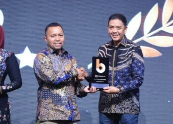 Mewakili Bupati Jember, Kadiskominfo Pemkab Jember saat Menerima penghargaan Beritajatim.com