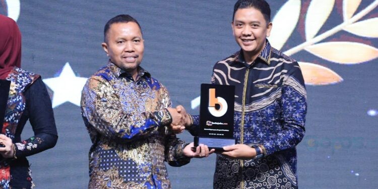 Mewakili Bupati Jember, Kadiskominfo Pemkab Jember saat Menerima penghargaan Beritajatim.com