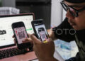 Warga melakukan transaksi digital menggunakan kode QRIS saat belanja menggunakan aplikasi dan website platfrom niaga elektronik (e-commerce) dari rumahnya di Semarang, Jawa Tengah, Jumat (31/10/2025). (ANTARA FOTO/Makna Zaezar/bar)