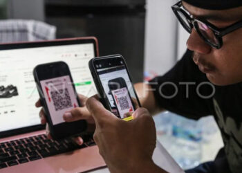 Warga melakukan transaksi digital menggunakan kode QRIS saat belanja menggunakan aplikasi dan website platfrom niaga elektronik (e-commerce) dari rumahnya di Semarang, Jawa Tengah, Jumat (31/10/2025). (ANTARA FOTO/Makna Zaezar/bar)