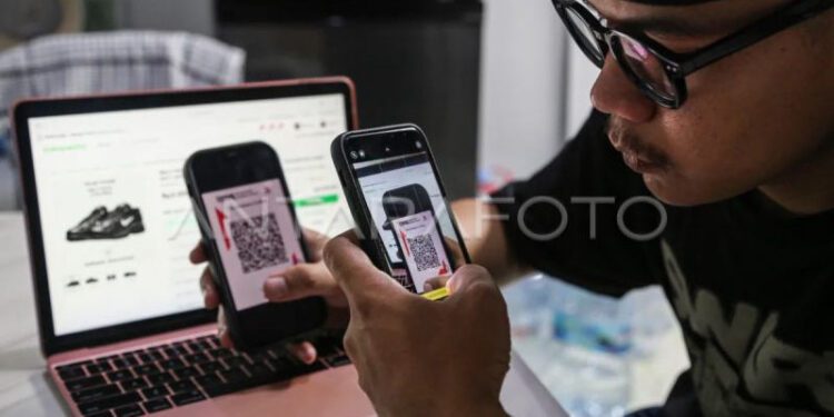 Warga melakukan transaksi digital menggunakan kode QRIS saat belanja menggunakan aplikasi dan website platfrom niaga elektronik (e-commerce) dari rumahnya di Semarang, Jawa Tengah, Jumat (31/10/2025). (ANTARA FOTO/Makna Zaezar/bar)