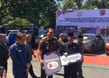 Bupati Ismet Mile didampingi Kajari Feddy Hantyo Nugroho pada penyerahan puluhan kendaraan dinas hasil permohonan bantuan hukum non litigasi dari Badan Keuangan dan Pendapatan Daerah (BKPD) kepada Kejaksaan Negeri Bone Bolango di halaman Kantor Kejaksaan Negeri Bone Bolango, Rabu (20/5/2026). (Foto Indra/Gopos)