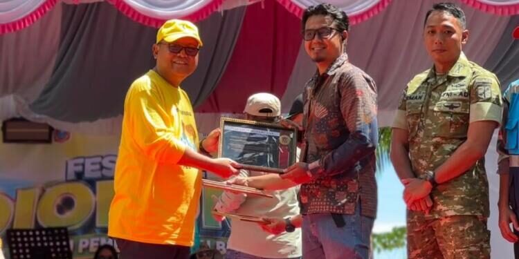 Pemberian piagam dari Bupati Gorontalo Utara Thariq Modanggu kepada PLN NP UP Gorontalo yang di wakili oleh TL SDM Umum dan CSR. (Foto.istimewa)