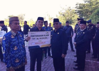 Bupati Bone Bolango, Ismet Mile didampingi Wabup Risman Tolingguhu, Sekda Iwan Mustapa dan jajaran Forkopimda saat menyerahkan santunan pensiun dan korpri kepada para ASN yang memasuki purna tugas di sela Peringatan Hari Lahir Pancasila tingkat Kabupaten Bone Bolango yang digelar di Lapangan Alun-Alun Bone Bolango, Selasa (2/6/2026). (Foto Indra/Gopos)