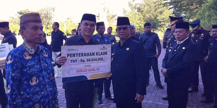 Bupati Bone Bolango, Ismet Mile didampingi Wabup Risman Tolingguhu, Sekda Iwan Mustapa dan jajaran Forkopimda saat menyerahkan santunan pensiun dan korpri kepada para ASN yang memasuki purna tugas di sela Peringatan Hari Lahir Pancasila tingkat Kabupaten Bone Bolango yang digelar di Lapangan Alun-Alun Bone Bolango, Selasa (2/6/2026). (Foto Indra/Gopos)