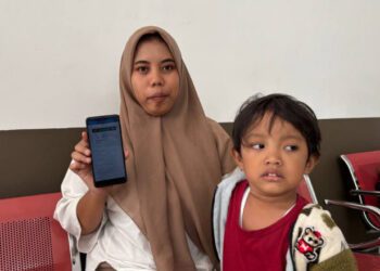 Intan Kurnia Andriani menunjukkan aplikasi mobile JKN. (Foto: Dok/Humas BPJS Kesehatan Cabang Jember)