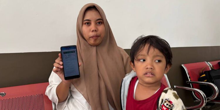 Intan Kurnia Andriani menunjukkan aplikasi mobile JKN. (Foto: Dok/Humas BPJS Kesehatan Cabang Jember)