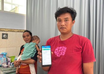 Benny Satria Indra Cahyadi menunjukkan aplikasi mobile JKN. (Foto: Dok/Humas BPJS Kesehatan Cabang Jember)
