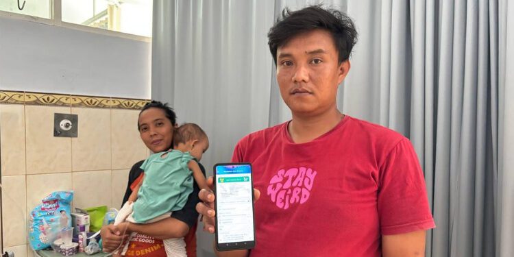 Benny Satria Indra Cahyadi menunjukkan aplikasi mobile JKN. (Foto: Dok/Humas BPJS Kesehatan Cabang Jember)