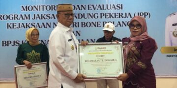 Bupati Ismet Mile saat menyerahkan piagam penghargaan kepada Kecamatan Tilongkabila atas capaian kepesertaan tertinggi di Bone Bolango, Kamis (4/6/2026). (Foto Indra/Gopos)