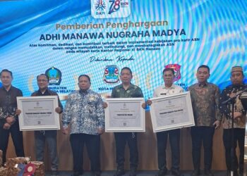 ekretaris Daerah Bone Bolango, Iwan Mustapa, didampingi Kepala BKPSDM Bone Bolango, Hamdy Gufran Mile saat menerima penghargaan Adhi Manawa Nugraha Pratama di Aula A.E. Manihuruk Kantor Regional XI BKN Manado, Sabtu (6/6/2026). (Foto Istimewa)