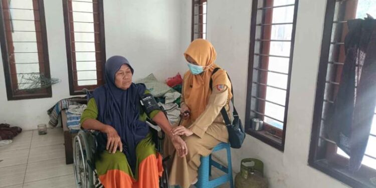 Petugas Puskesmas Ambulu saat kontrol rumah pasien yang sedang mangalami sakit dan halangan ke Puskesmas