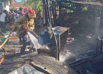 Petugas Damkar Kabupaten Gorontalo saat melakukan pendinginan sisa-sisa kebakaran di rumah desa Isimu.(F.istimewa)