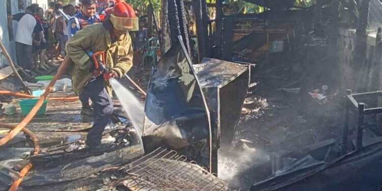 Petugas Damkar Kabupaten Gorontalo saat melakukan pendinginan sisa-sisa kebakaran di rumah desa Isimu.(F.istimewa)
