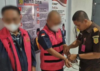 Tersangka RI selaku KPA dan DZA selaku pelaksana proyek saat diborgol aparat Kejari Bone Bolango.(F. Istimewa)