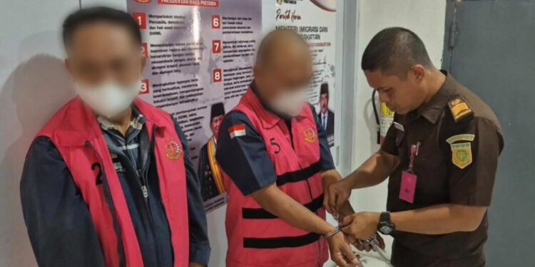 Tersangka RI selaku KPA dan DZA selaku pelaksana proyek saat diborgol aparat Kejari Bone Bolango.(F. Istimewa)