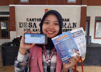 Dhia Silmi Danisha menunjukkan layanan Mobile JKN. (Foto: Dok/Humas BPJS Kesehatan Cabang Jember)