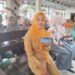 Linda Khoirun Nisa menunjukkan layanan Mobile JKN. (Foto: Dok/Humas BPJS Kesehatan Cabang Jember)