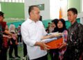 Wali Kota Surabaya Eri Cahyadi (tengah) menyerahkan paket bantuan pendidikan kepada pelajar SMA/SMK/MA sederajat di Gelanggang Remaja Surabaya, Jumat (10/7/2026). Bantuan pendidikan Pemerintah Kota Surabaya tersebut menjangkau 7.380 siswa dari keluarga miskin dan prasejahtera melalui pemberian seragam sekolah, sepatu, kaus kaki, serta bantuan biaya pendidikan Rp350 ribu per bulan bagi siswa sekolah swasta. ANTARA/HO-Diskominfotik Surabaya.