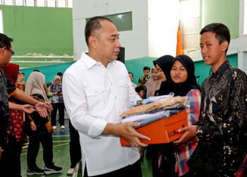 Wali Kota Surabaya Eri Cahyadi (tengah) menyerahkan paket bantuan pendidikan kepada pelajar SMA/SMK/MA sederajat di Gelanggang Remaja Surabaya, Jumat (10/7/2026). Bantuan pendidikan Pemerintah Kota Surabaya tersebut menjangkau 7.380 siswa dari keluarga miskin dan prasejahtera melalui pemberian seragam sekolah, sepatu, kaus kaki, serta bantuan biaya pendidikan Rp350 ribu per bulan bagi siswa sekolah swasta. ANTARA/HO-Diskominfotik Surabaya.