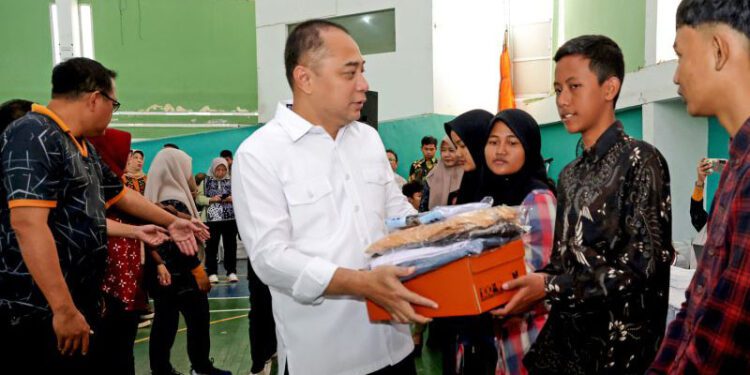 Wali Kota Surabaya Eri Cahyadi (tengah) menyerahkan paket bantuan pendidikan kepada pelajar SMA/SMK/MA sederajat di Gelanggang Remaja Surabaya, Jumat (10/7/2026). Bantuan pendidikan Pemerintah Kota Surabaya tersebut menjangkau 7.380 siswa dari keluarga miskin dan prasejahtera melalui pemberian seragam sekolah, sepatu, kaus kaki, serta bantuan biaya pendidikan Rp350 ribu per bulan bagi siswa sekolah swasta. ANTARA/HO-Diskominfotik Surabaya.
