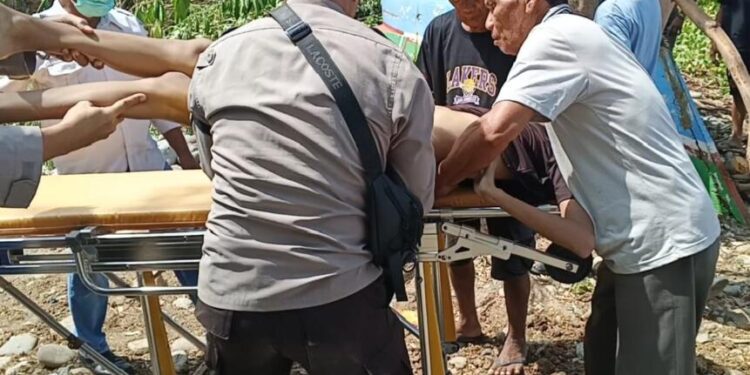 Aparat kepolisian bersama warga setempat saat mengevakuasi korban.(F. Istimewa)
